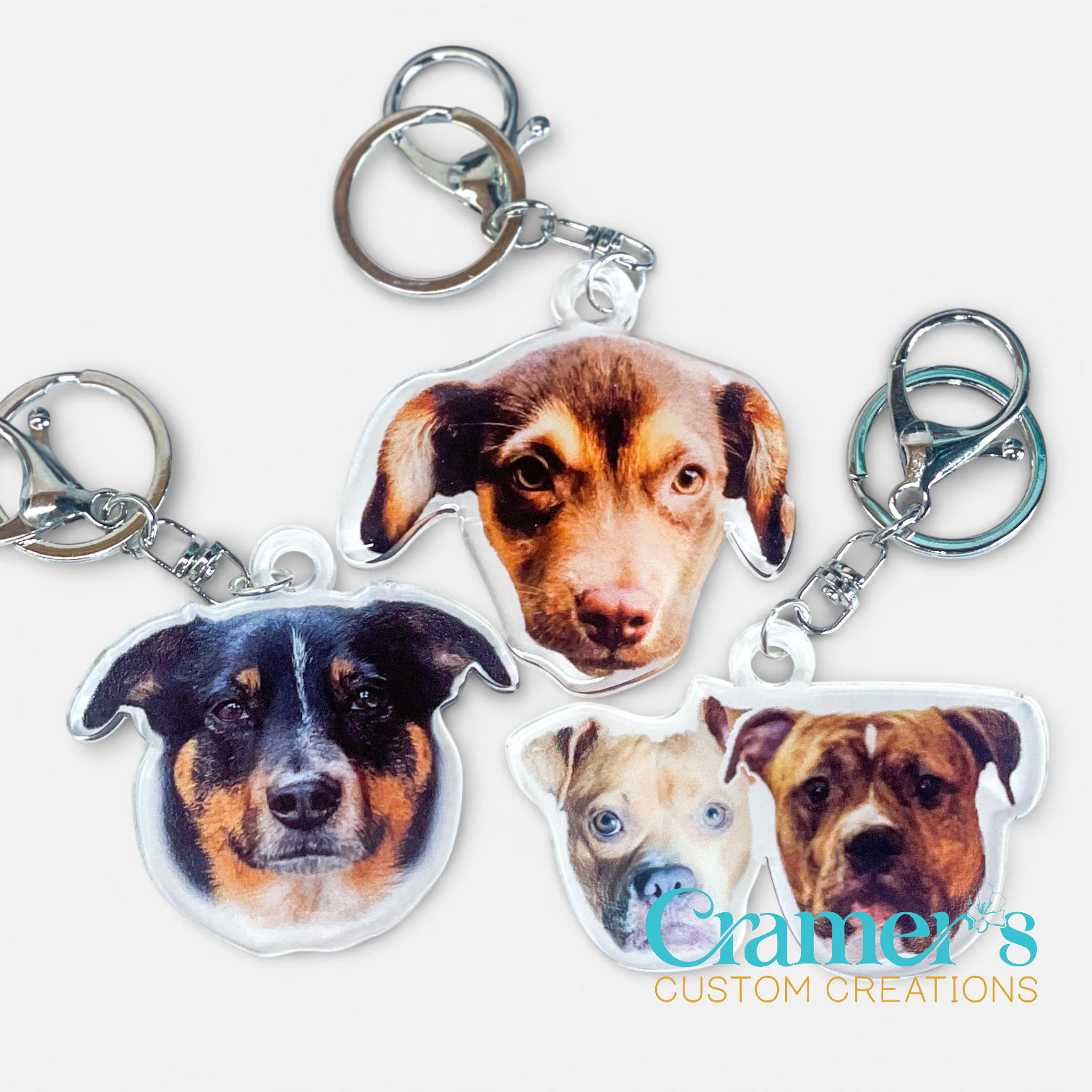 Keychains with dog faces and 'Cramer's Custom Creations' branding on a white background