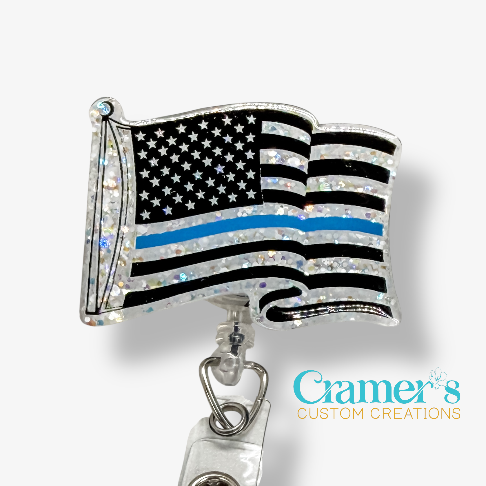 American flag badge holder with thin blue line on a white background, featuring Cramer's Custom Creations branding.