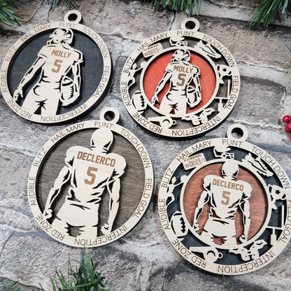 Four sports-themed ornaments with different designs on a stone surface.