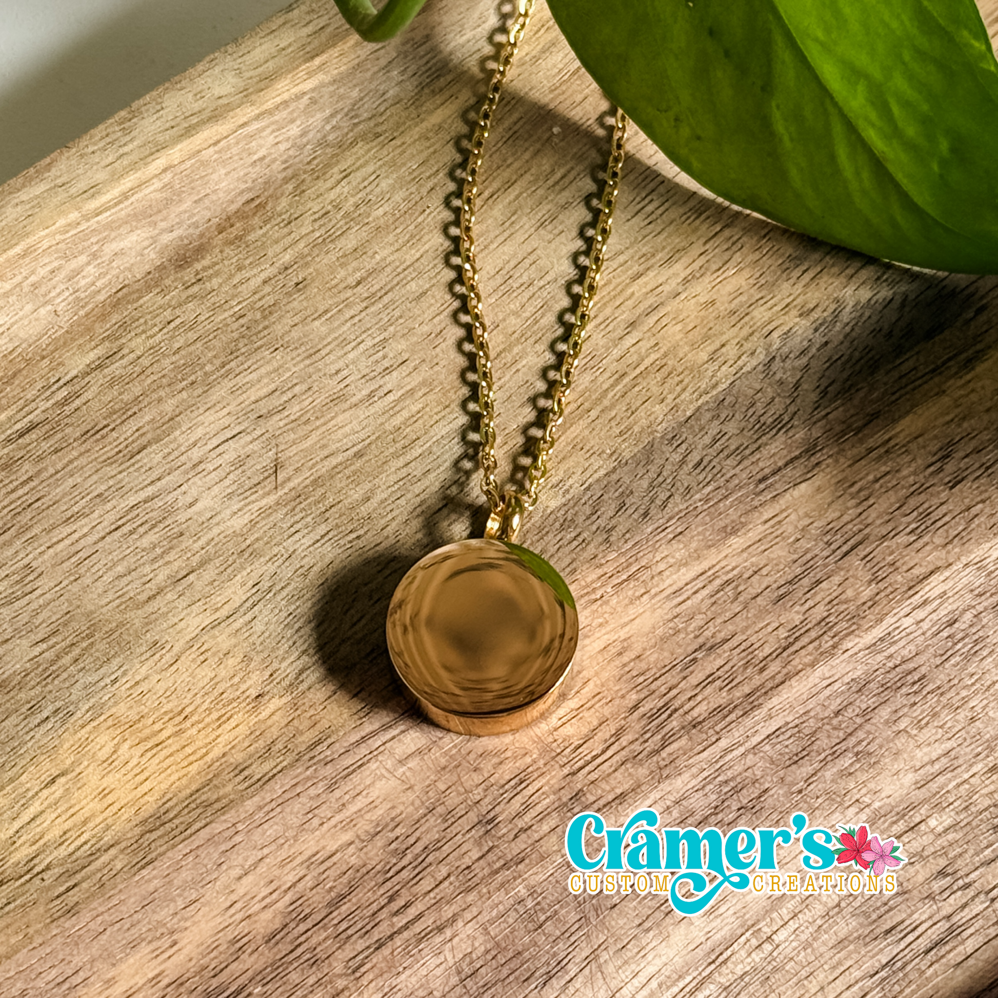 a gold circle urn necklace on a wood background
