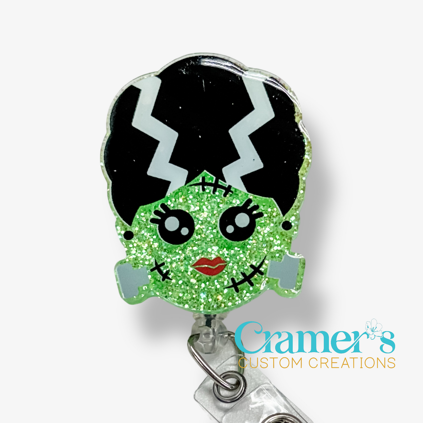 Character-shaped badge holder with green face and black hair on a white background, featuring 'Cramer's Custom Creations' logo.