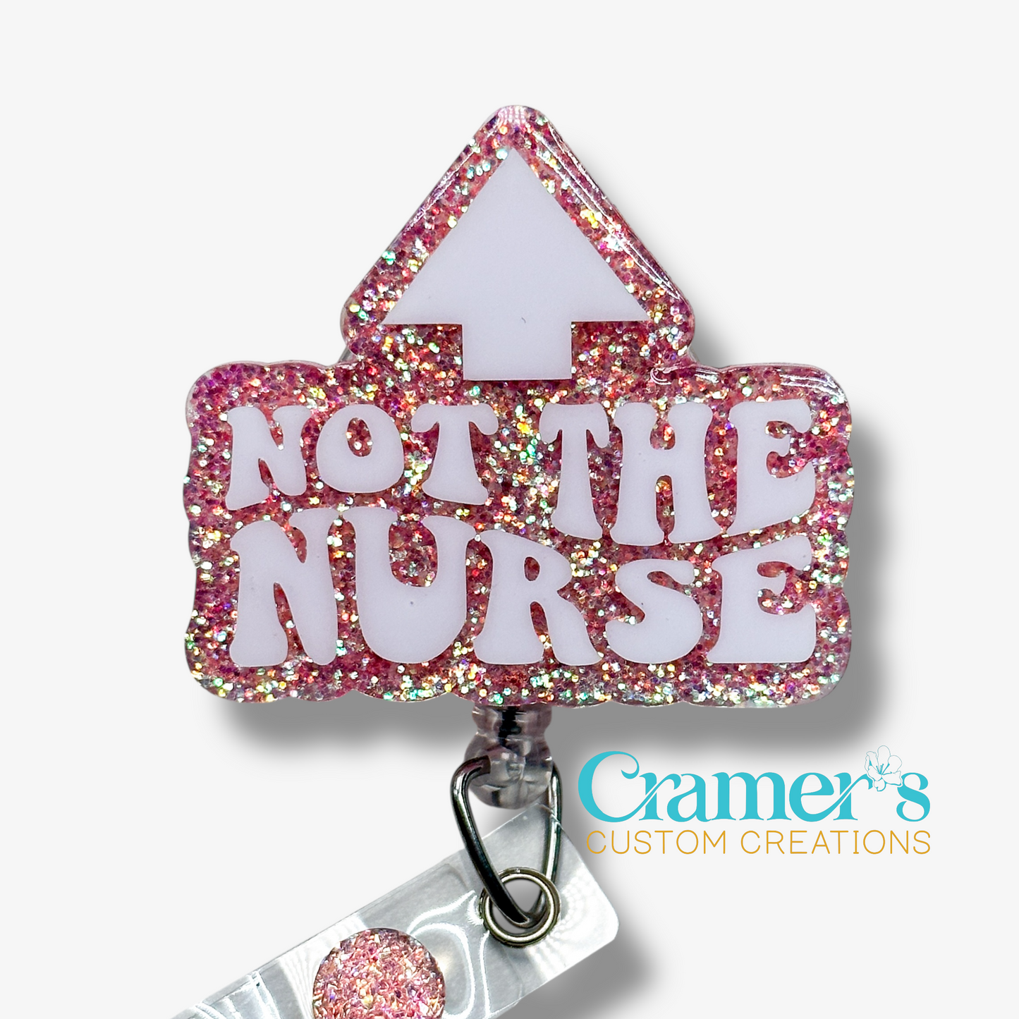 Glittery badge holder with 'Not the Nurse' text on a white background, featuring Cramer's Custom Creations logo.