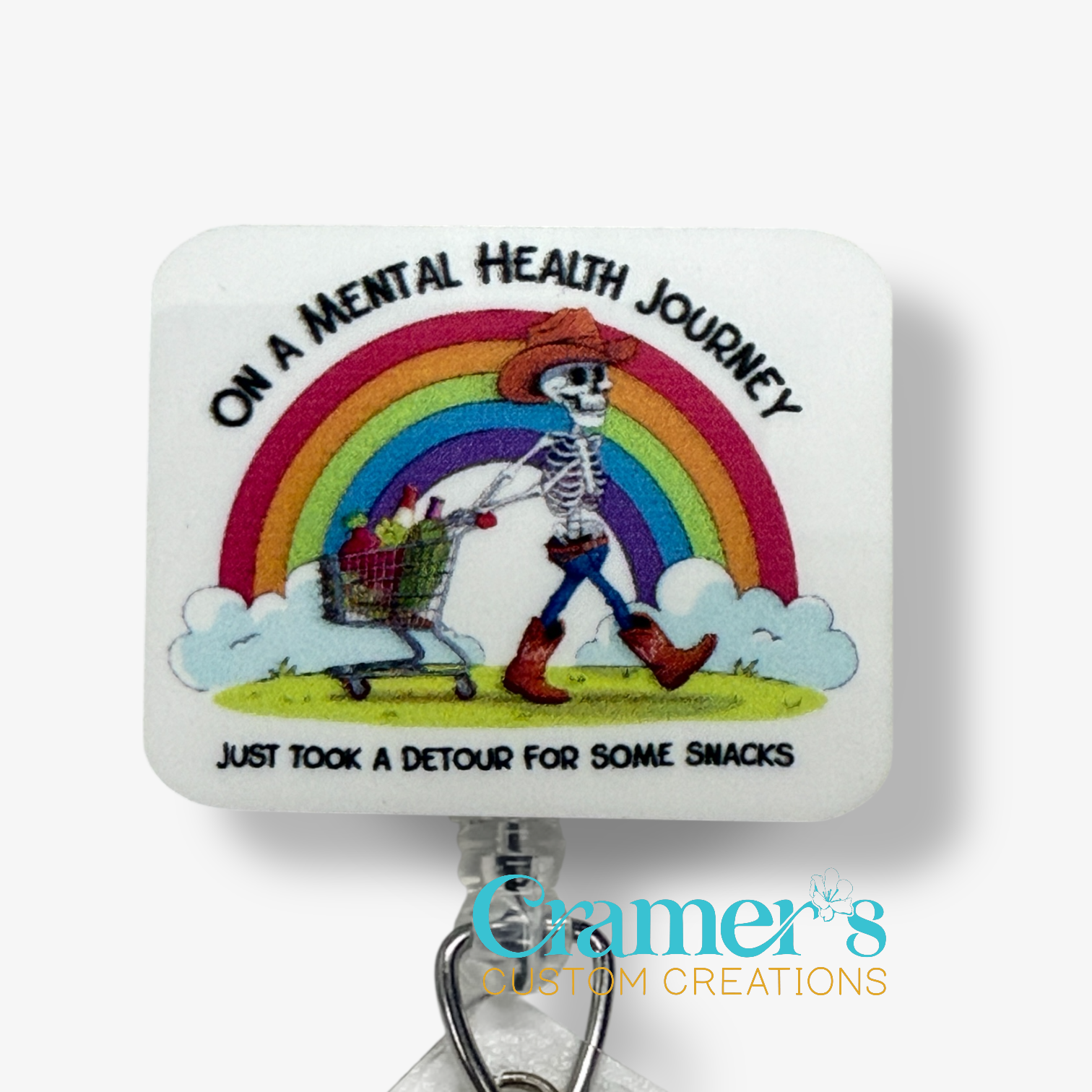 Skeletal figure with a shopping cart under a rainbow, text 'On a Mental Health Journey, took a detour for snacks', Cramer's Custom Creations logo.