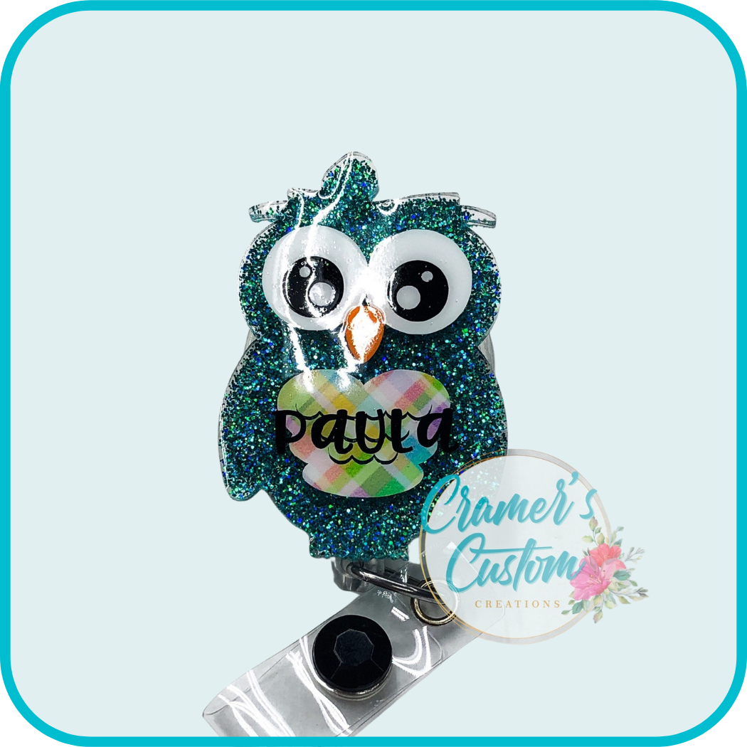 Dark teal owl with a plaid chest with the name paula on it