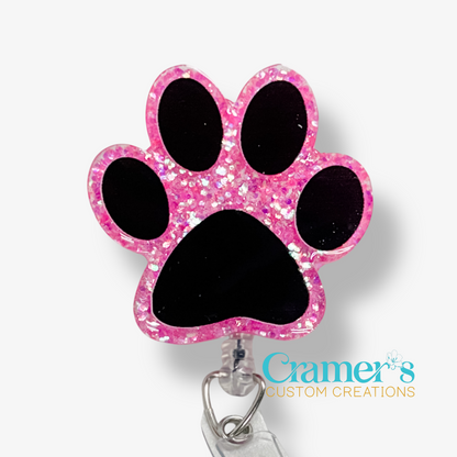 Pink glittery paw-shaped badge holder with a white background