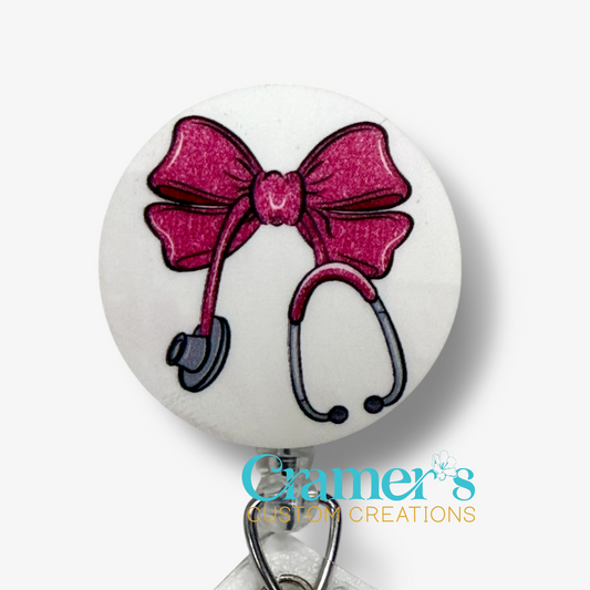 Stethoscope with pink bow on a white background, featuring Cramer's Custom Creations logo.