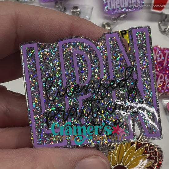 video of badge reel showing a silver glitter background with the initials in purple and licensed practical nurse in black