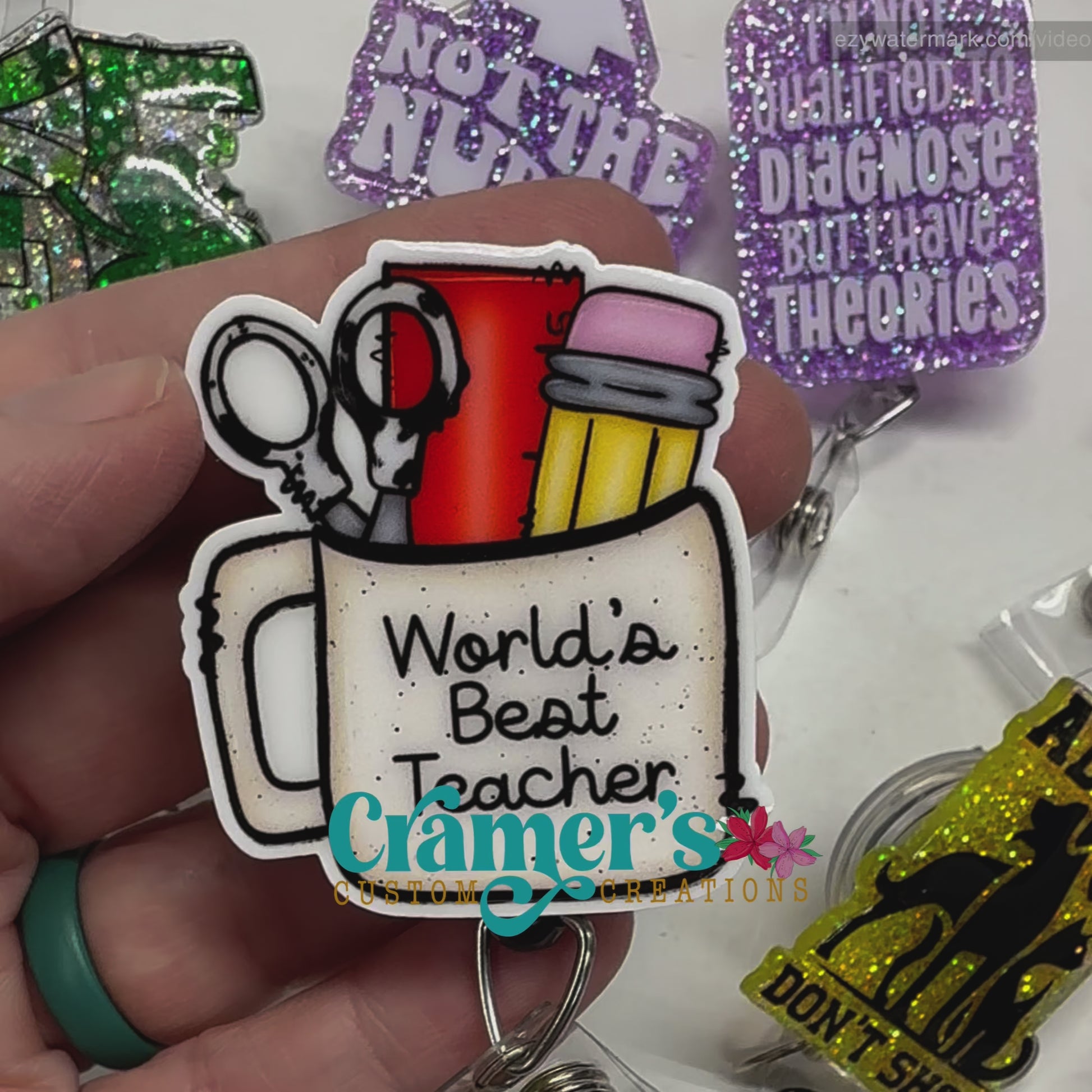 video of badge reel showing a non glitter option of a badge with a coffee mug filled with teacher items and the words worlds best teacher