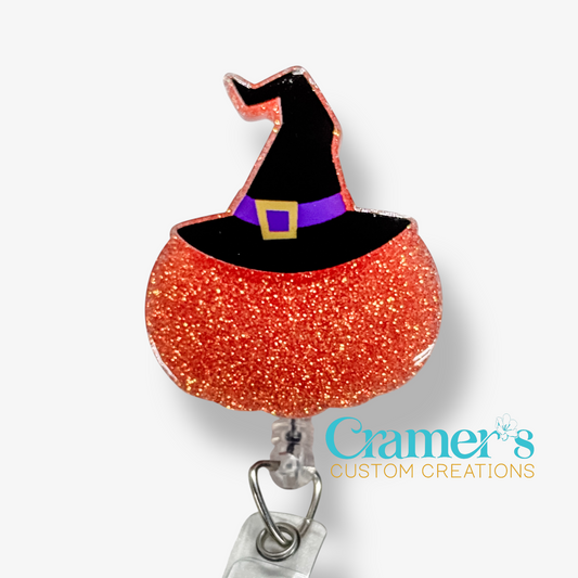Orange glittery cauldron with a black witch hat on a white background, featuring Cramer's Custom Creations logo.