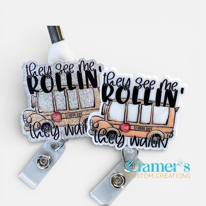 School bus badge reel that says they see me rollin, they waitin