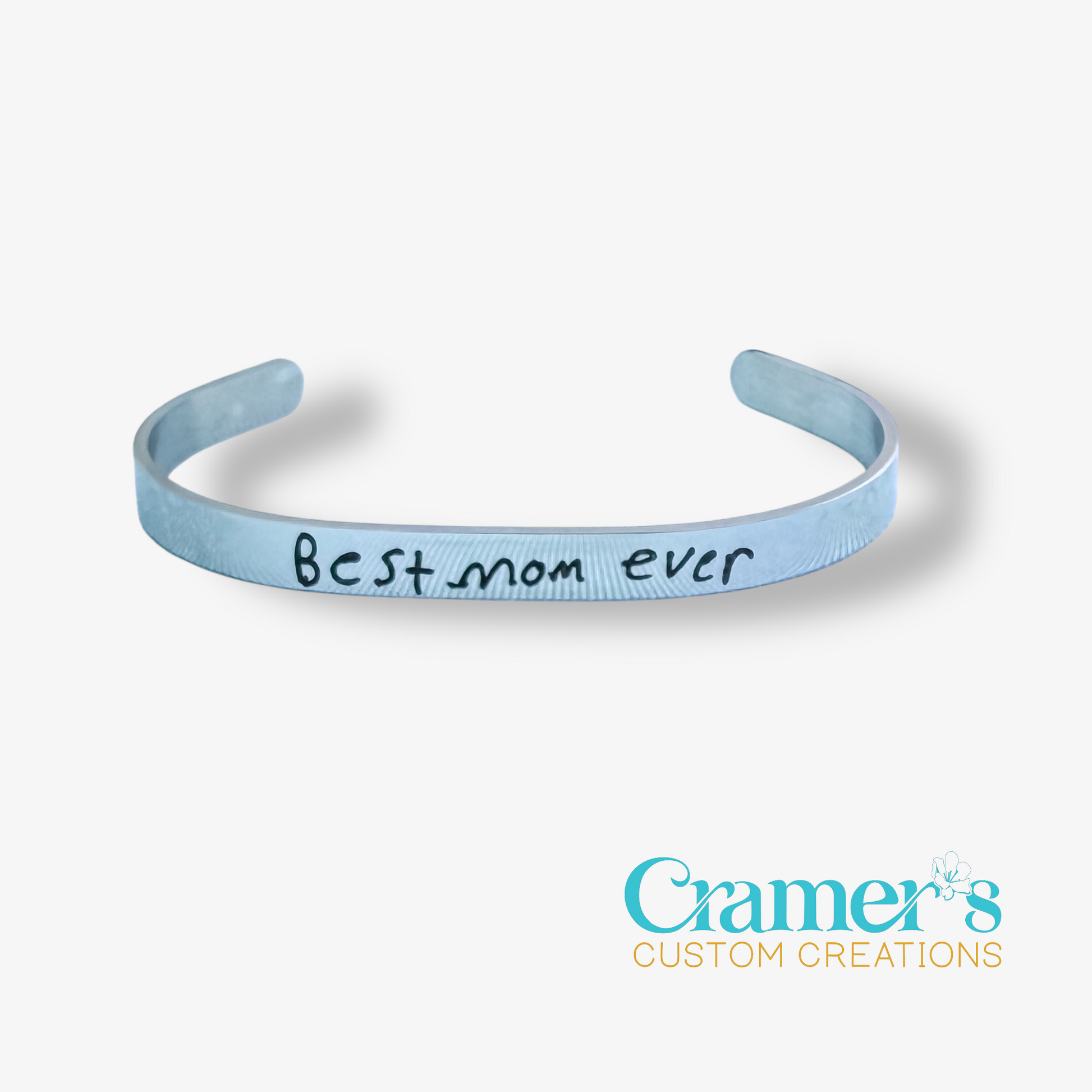 silver bracelet with 'Best mom ever' text on a white background, featuring Cramer's Custom Creations logo.