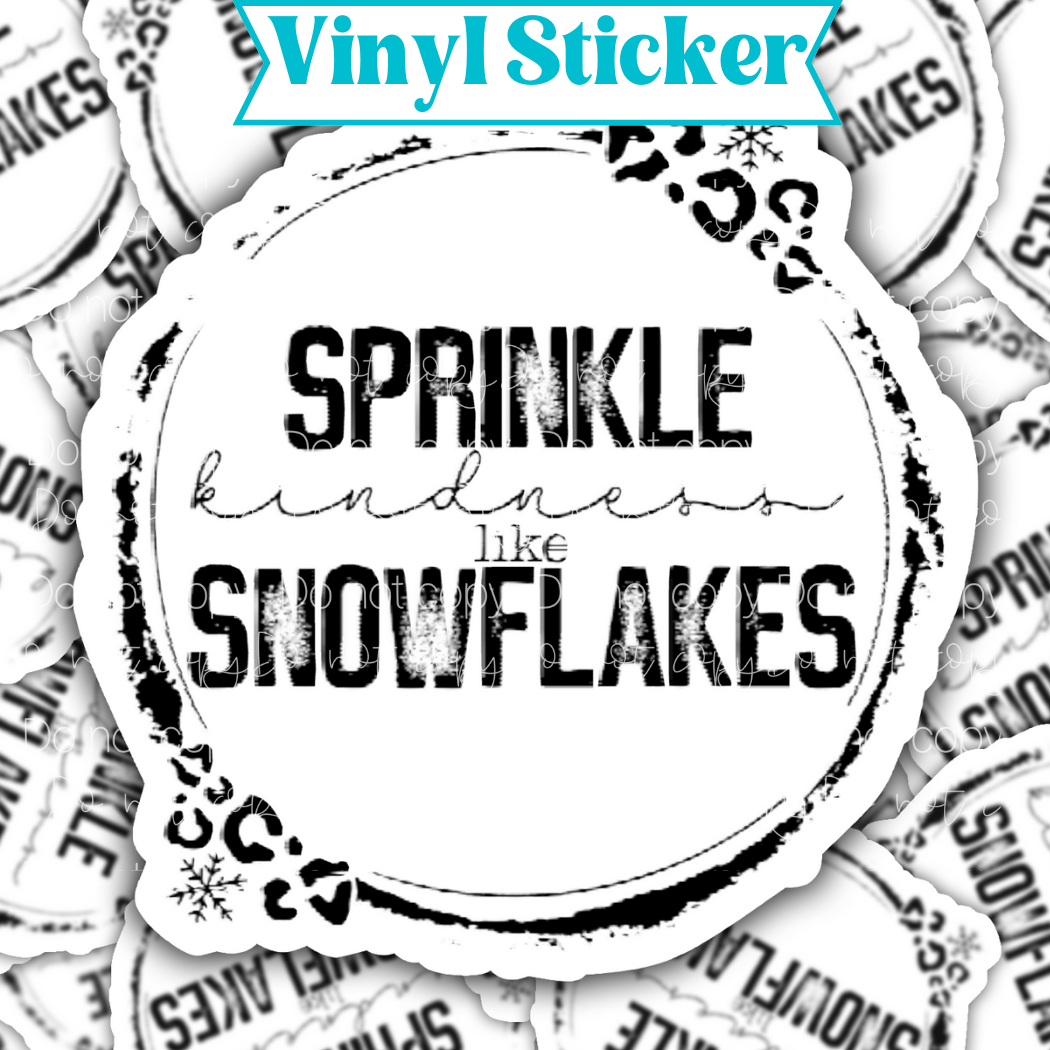 Sticker laying flat that says sprinkle kindness like snowflakes on a background of the same sticker stacked up