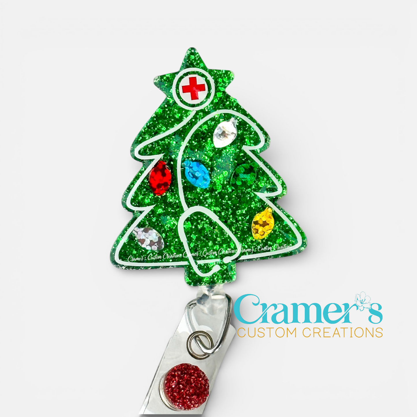 Decorative Christmas tree-shaped badge holder with colorful decorations on a white background, featuring the brand 'Cramer's Custom Creations'.