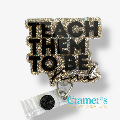 badge reel showing a gold glitter background with teach them to be kind in black