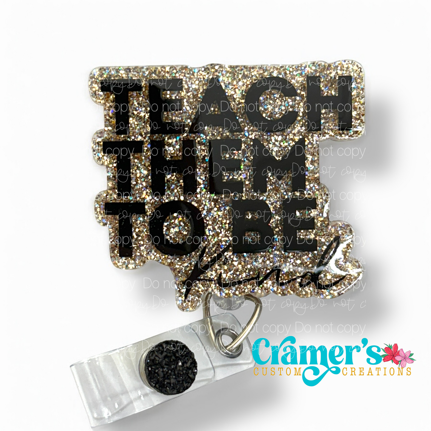 badge reel showing a gold glitter background with teach them to be kind in black