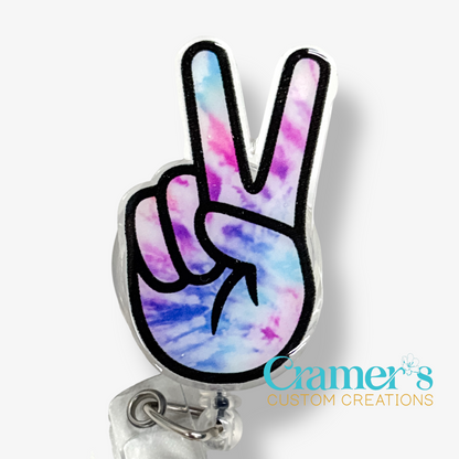 Tie-dye peace sign badge holder with 'Cramer's Custom Creations' logo on a white background
