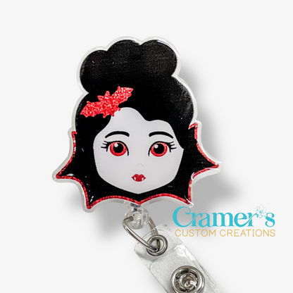 Character-shaped badge holder with black hair and red eyes on a white background, featuring 'Cramer's Custom Creations' branding.