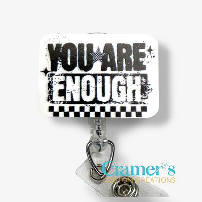 Motivational quote 'YOU ARE ENOUGH' on a badge reel topper with 'Cramer's Custom Creations' branding.