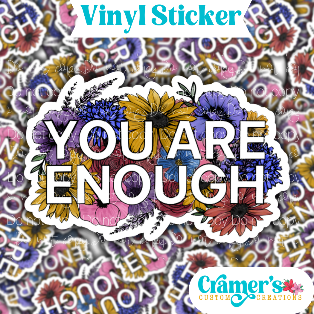 Sticker laying flat that says iyou are enough with flowers on a background of the same sticker stacked up