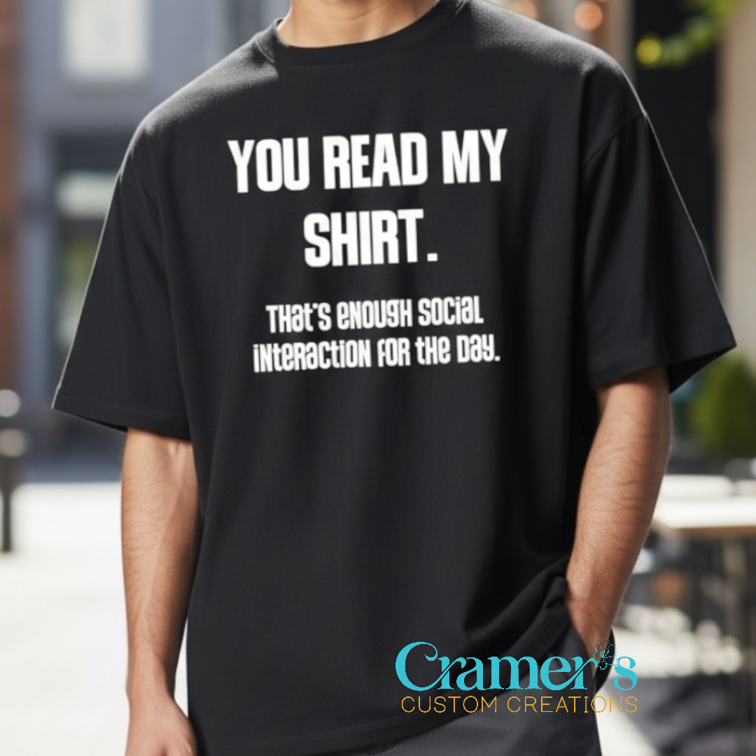 Person wearing a black t-shirt with humorous text, standing outdoors.