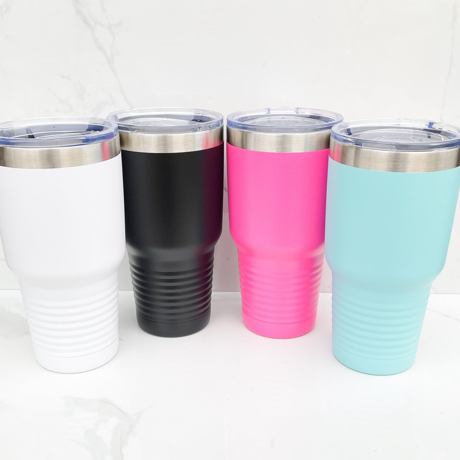 4 30 oz tumblers in white, black, pink, and teal colors on a white background