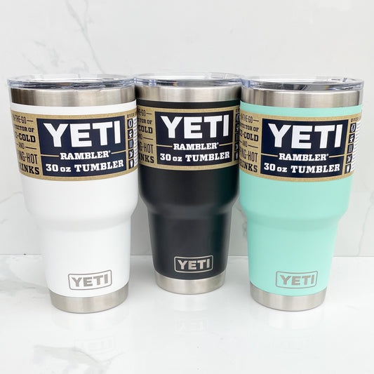 three 30 oz yeti tumblers, white, black, and teal on a white background