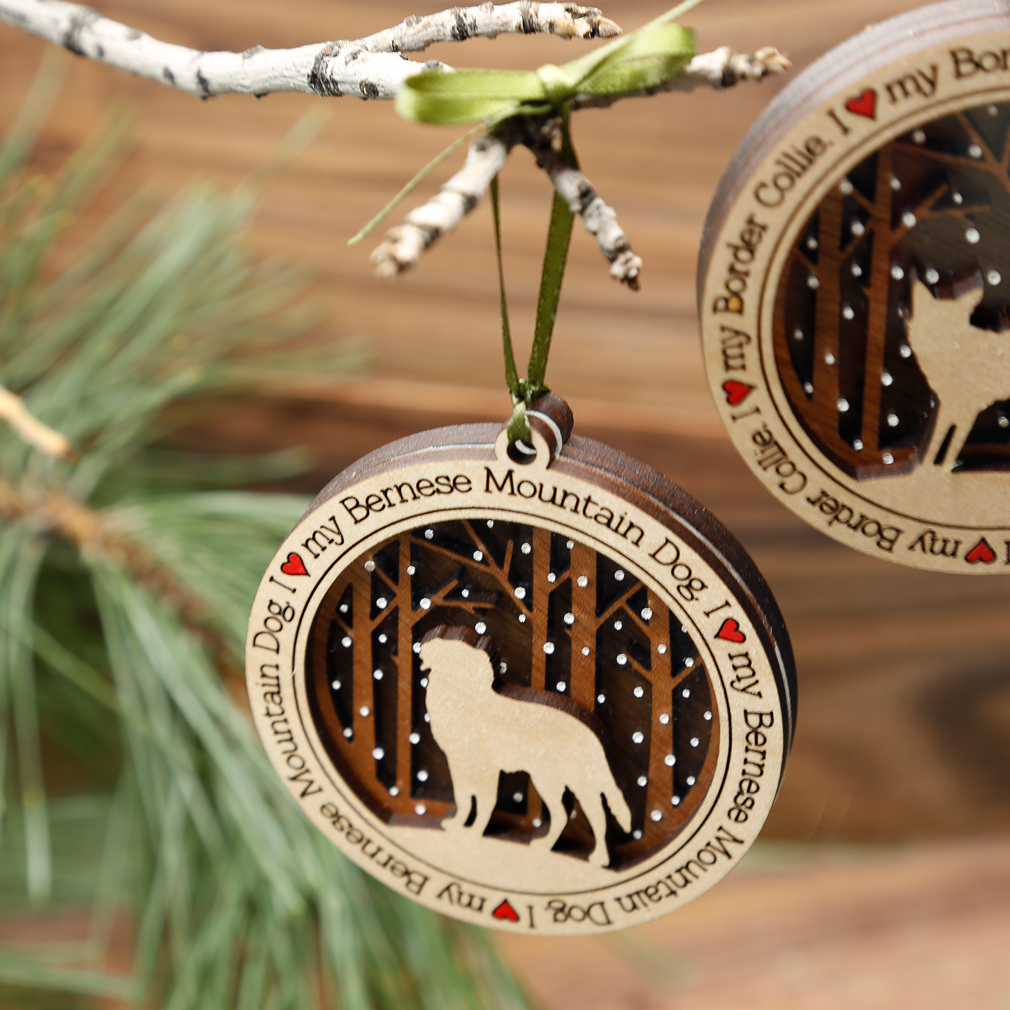 A wooden ornament depicting a stylized dog design with a Christmas tree in the background, part of the 'I Love My Dog Ornament Series'.
