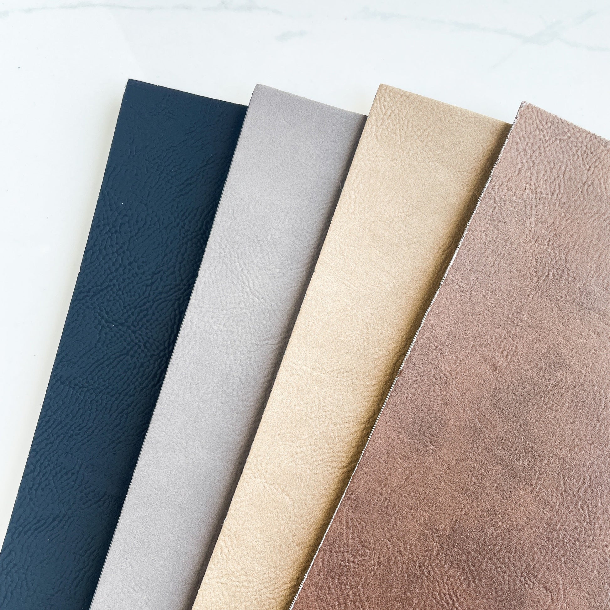4 sheets of leather in different colors on a white background