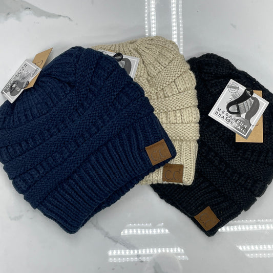Three beanie hats in navy, beige, and black colors, displayed flat with leather patches on the fold.