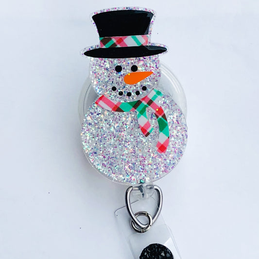badge reel with a snowman laying on a flat white surface