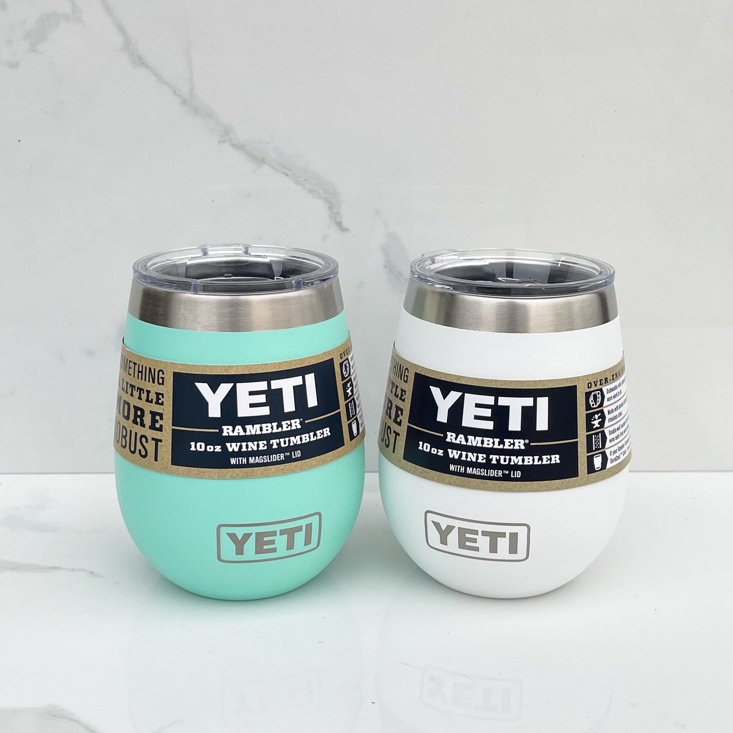 Two yeti wine tumblers, one teal and one white on a white background