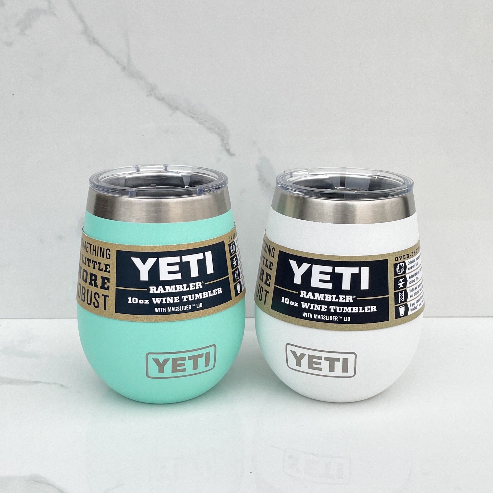 Two yeti wine tumblers, one teal and one white on a white background